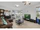 Cozy living room with tile floors, a ceiling fan, comfortable seating, and lots of natural light at 12810 Daisy Pl, Bradenton, FL 34212