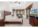 Inviting main bedroom with a large bed, wooden furniture, and views of the outdoor pool at 12810 Daisy Pl, Bradenton, FL 34212