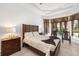 Cozy main bedroom showcasing a well-made bed, bedside tables, chairs, and beautiful backyard views at 12810 Daisy Pl, Bradenton, FL 34212