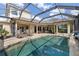 Beautiful screened-in pool area with comfortable lounge chairs and lush landscaping around the perimeter at 12810 Daisy Pl, Bradenton, FL 34212