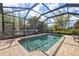 Relaxing screened-in pool with brick patio and lush landscaping provides a private outdoor oasis at 12810 Daisy Pl, Bradenton, FL 34212