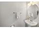 Modern powder room with a pedestal sink, oval mirror, and chrome fixtures at 12810 Daisy Pl, Bradenton, FL 34212