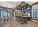 This wet bar features dark wood cabinetry, recessed lighting, countertop seating and two tv's at 14733 Como Cir, Lakewood Ranch, FL 34202