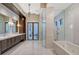This primary bathroom features a soaking tub, walk-in shower, double vanity and white marble countertops at 14733 Como Cir, Lakewood Ranch, FL 34202