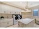 Spacious laundry room featuring modern appliances, ample storage, and a convenient island workspace at 14733 Como Cir, Lakewood Ranch, FL 34202