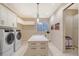 Well-equipped laundry room with modern washer/dryer, custom cabinets, and a functional island for folding at 14733 Como Cir, Lakewood Ranch, FL 34202
