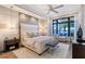 This primary bedroom features a neutral color palette, tray ceiling, and water views at 14733 Como Cir, Lakewood Ranch, FL 34202