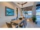 Covered outdoor dining space overlooking water, featuring custom lighting and modern furnishings at 14733 Como Cir, Lakewood Ranch, FL 34202