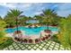 Aerial view of a beautiful pool area with palm trees, lounge chairs, and lush landscaping at 14733 Como Cir, Lakewood Ranch, FL 34202