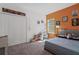 Comfortable bedroom with closet, orange accent wall, a desk, and carpet flooring at 1901 Everson St, Bradenton, FL 34208