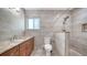 Modern bathroom featuring tiled walls, granite vanity, toilet and walk-in shower with rainfall shower head at 3085 Goldenrod St, Sarasota, FL 34239