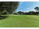 Expansive golf course with well-manicured green and a sand trap, set against a backdrop of mature trees at 3085 Goldenrod St, Sarasota, FL 34239