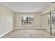 Bedroom featuring neutral paint, soft carpet, a large window, and a mirrored closet at 3629 Longmeadow # 38, Sarasota, FL 34235
