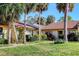 Charming villa with a red tile roof surrounded by mature landscaping and palm trees at 3629 Longmeadow # 38, Sarasota, FL 34235
