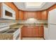 Bright kitchen with wood cabinets, granite counters and modern white appliances at 3629 Longmeadow # 38, Sarasota, FL 34235