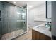 Beautiful bathroom featuring double sinks, wood cabinets, and a glass shower with decorative tile floor at 400 Dona Dr, Nokomis, FL 34275