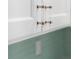 Close-up of elegant white cabinets with modern, clear hardware and complementing, light green subway tile backsplash at 400 Dona Dr, Nokomis, FL 34275