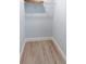 Compact walk-in closet features shelving and wood-look flooring, providing efficient storage solutions at 400 Dona Dr, Nokomis, FL 34275