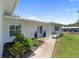 Charming single-story home with a manicured lawn, attractive landscaping, and a welcoming blue front door at 400 Dona Dr, Nokomis, FL 34275