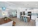 Open-concept kitchen with an island, white cabinets, stainless steel appliances, and views to the living room at 400 Dona Dr, Nokomis, FL 34275