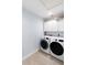 Bright laundry room with white cabinets and modern front-load washer and dryer at 400 Dona Dr, Nokomis, FL 34275
