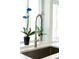 Close up of kitchen sink with steel faucet, quartz countertops, and potted orchid at 400 Dona Dr, Nokomis, FL 34275
