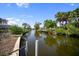 Beautiful canal view with docks and lush landscaping along the waterway under a bright blue sky at 400 Dona Dr, Nokomis, FL 34275
