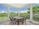An exterior balcony featuring a full dining set, outdoor seating and a view of lush green trees and landscaping at 4207 Marina View Way, Cortez, FL 34215
