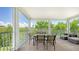 An exterior balcony featuring a full dining set, outdoor seating and a view of lush green trees and landscaping at 4207 Marina View Way, Cortez, FL 34215