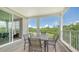 An exterior balcony featuring a full dining set, outdoor seating and a view of lush green trees and landscaping at 4207 Marina View Way, Cortez, FL 34215