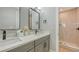 This bathroom features a double sink vanity, stone countertop, and frameless mirror at 4207 Marina View Way, Cortez, FL 34215