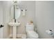 Cozy powder room featuring pedestal sink, neutral decor, and a modern toilet, offering a clean and functional space at 4207 Marina View Way, Cortez, FL 34215