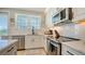 Modern kitchen with stainless steel appliances, white cabinets, and tile backsplash at 4207 Marina View Way, Cortez, FL 34215