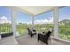 Relaxing lanai with comfortable seating offering scenic views of lush greenery and distant rooftops on a sunny day at 4207 Marina View Way, Cortez, FL 34215