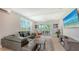 A spacious living room with a comfortable sectional sofa, a ceiling fan and sliding glass doors to the exterior balcony at 4207 Marina View Way, Cortez, FL 34215