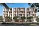 Modern condominium exterior with sleek design, private balconies, and manicured trees at 430 Kumquat Ct # 206, Sarasota, FL 34236