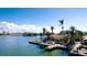 Idyllic waterfront shot of a private boat dock with lush greenery and clear blue skies at 542 67Th St, Holmes Beach, FL 34217