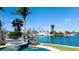 Waterfront home featuring a beautiful blue pool, spa, and tropical landscaping on a sunny day at 542 67Th St, Holmes Beach, FL 34217