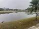 Scenic view of a tranquil lake surrounded by lush greenery and community homes on a cloudy day at 7211 W Country Club N Dr # 135, Sarasota, FL 34243