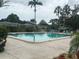 Community pool featuring a concrete deck, lounge chairs, and tropical landscaping at 7211 W Country Club N Dr # 135, Sarasota, FL 34243