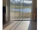Bright interior shot showcasing the serene lake view through sliding glass doors leading to the outdoor living space at 7211 W Country Club N Dr # 135, Sarasota, FL 34243