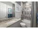 Updated bathroom featuring a shower/tub combo with marble-style tile and granite counters at 833 Honeyflower Loop, Bradenton, FL 34212