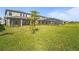 View of a lush backyard featuring a well-maintained lawn, screened-in porch, and vibrant landscaping at 8609 Evening Dr, Sarasota, FL 34241