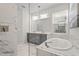 Beautiful bathroom features double vanity, soaking tub and glass enclosed shower with marble-style tile at 8609 Evening Dr, Sarasota, FL 34241