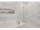 Bright bathroom featuring soaking tub and glass-enclosed shower with marble-style tile at 8609 Evening Dr, Sarasota, FL 34241