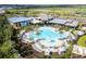 Aerial view of a lavish community pool with palm trees, lounge chairs, and a water slide at 8609 Evening Dr, Sarasota, FL 34241