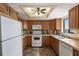 Kitchen features a light ceiling fan, tile backsplash, white appliances, and natural wood cabinets at 900 Gulf Blvd # 805, Indian Rocks Beach, FL 33785