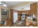 Eat-in kitchen featuring tile floors, wood cabinets, white appliances, and a light, neutral countertop at 900 Gulf Blvd # 805, Indian Rocks Beach, FL 33785