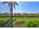 Waterfront backyard with green lawn and a scenic canal view from a screened in lanai at 104 Inlets Blvd # 104, Nokomis, FL 34275
