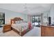 Calming bedroom with a decorative bed frame, sliding glass doors to lanai, and neutral tones at 104 Inlets Blvd # 104, Nokomis, FL 34275